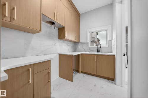 Light wood-finish cabinetry, white countertops, and a white tile backsplash - 8737 Mayday Lane Sw, Edmonton, AB 