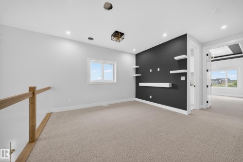 Recessed lighting, contemporary light fixture, built-in shelving, light-colored carpeting, and a window with white trim - 8737 Mayday Lane Sw, Edmonton, AB 