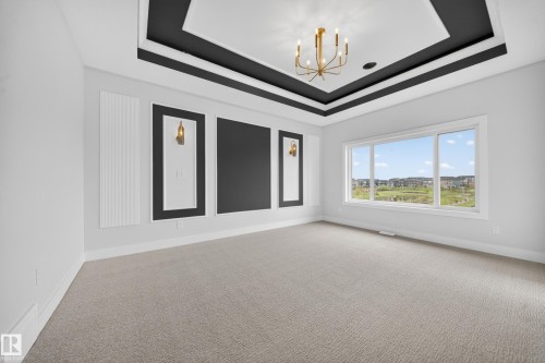 Tray ceiling with contrasting trim and a brass-tone chandelier - 8737 Mayday Lane Sw, Edmonton, AB 