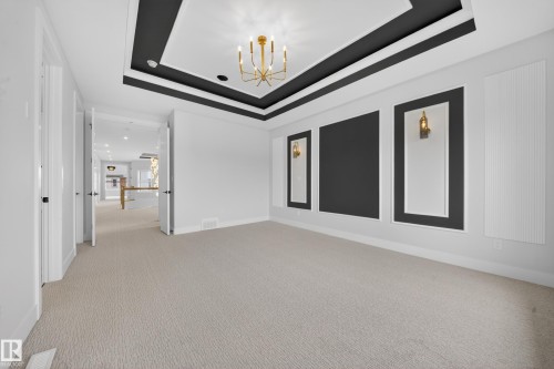 Tray ceiling with recessed lighting and a central chandelier - 8737 Mayday Lane Sw, Edmonton, AB 