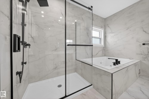 Glass-enclosed shower with matte black fixtures, rain shower head, and an integrated bench - 8737 Mayday Lane Sw, Edmonton, AB 