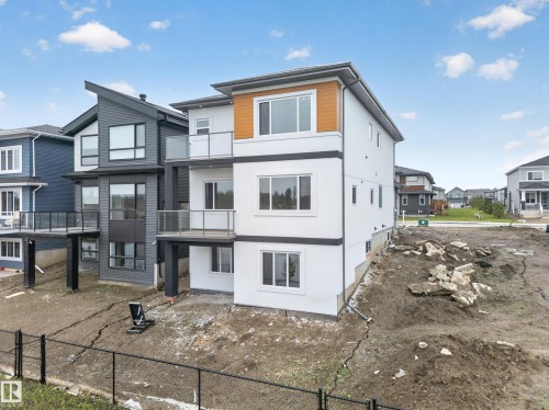 Contemporary exterior with white stucco and wood-finish siding accents - 8737 Mayday Lane Sw, Edmonton, AB 