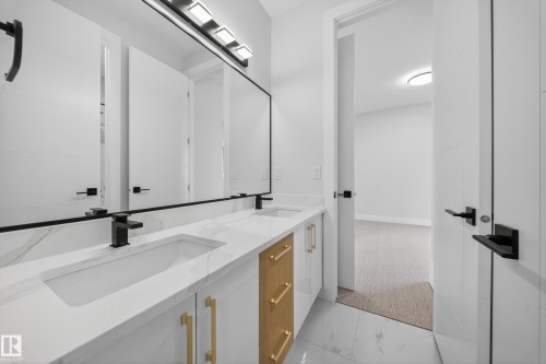 Dual vanity with integrated sinks, marble-patterned countertop, gold-tone hardware, and matte black faucets - 8737 Mayday Lane Sw, Edmonton, AB 