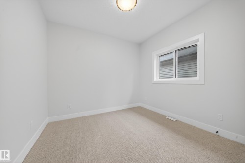 Neutral wall finishes, recessed window, light-colored carpeting, and flush mount lighting - 8737 Mayday Lane Sw, Edmonton, AB 