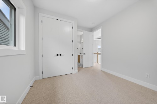 Neutral-toned carpeting, white walls, and a window with white trim - 8737 Mayday Lane Sw, Edmonton, AB 