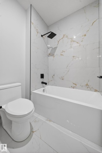 White tile flooring, white bathtub, black shower fixtures, and white toilet - 8737 Mayday Lane Sw, Edmonton, AB 