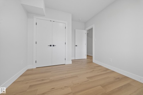 Wood-finish flooring, white walls, and white trim - 8737 Mayday Lane Sw, Edmonton, AB 