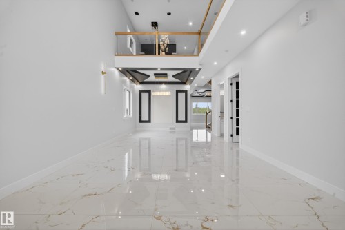 Polished tile flooring, recessed lighting, and a second-story balcony with glass railing - 8737 Mayday Lane Sw, Edmonton, AB 