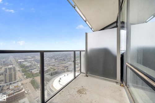 Balcony with concrete flooring, glass and metal railing, frosted glass privacy screens, and adjacent full-height windows - #4007 10360 102 St Nw, Edmonton, AB 