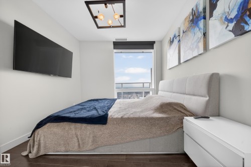 Floor-to-ceiling window with roller shade, wood-finish flooring, and a modern ceiling light fixture - #4007 10360 102 St Nw, Edmonton, AB 