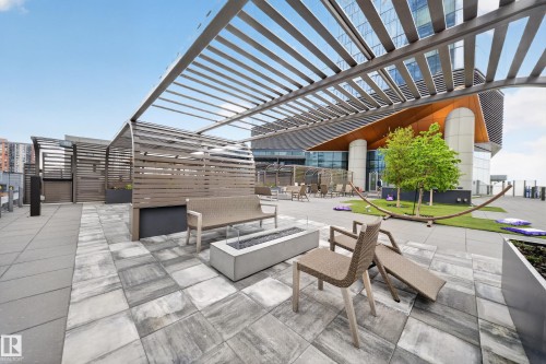 Rooftop patio featuring a metal pergola, pavers, a fire pit, and privacy screening - #4007 10360 102 St Nw, Edmonton, AB 