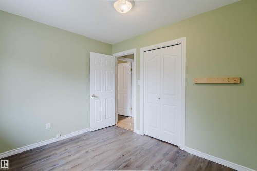 Room featuring wood-finish flooring, light green painted walls, and white baseboards - 2439 112 Street Nw, Edmonton, AB - Indoor
