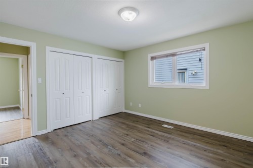 Room featuring wood-finish flooring, light green walls, and a white window frame with blinds - 2439 112 Street Nw, Edmonton, AB - Indoor Photo Showing Other Room