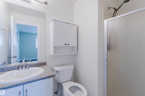 Full bathroom featuring a white vanity with an integrated sink, speckled countertop, and chrome faucet - 2439 112 Street Nw, Edmonton, AB - Indoor Photo Showing Bathroom