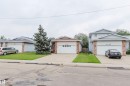 Exterior featuring a single-car garage, light-colored siding, and brick accents - 2439 112 Street Nw, Edmonton, AB  - Outdoor With Facade 