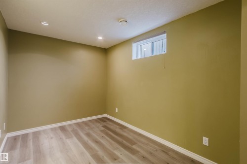 Room featuring wood-finish flooring, recessed lighting, a white trim baseboard, and a high-set window - 2439 112 Street Nw, Edmonton, AB - Indoor Photo Showing Other Room