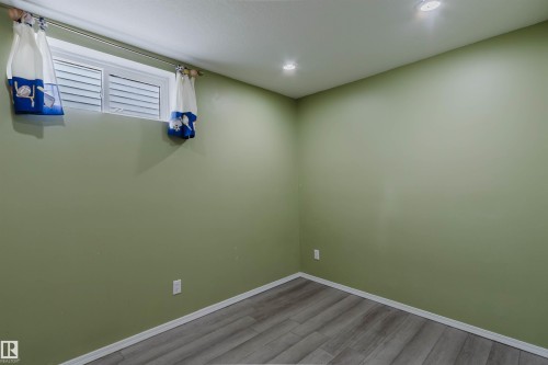 Room featuring light green walls, recessed lighting, and wood-finish flooring - 2439 112 Street Nw, Edmonton, AB - Indoor