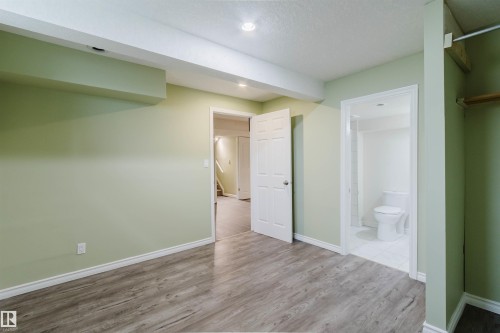 Room featuring wood-finish flooring, recessed lighting, and light green walls - 2439 112 Street Nw, Edmonton, AB - Indoor Photo Showing Other Room