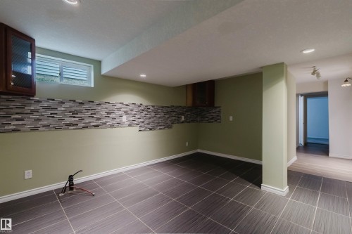 Spacious lower level featuring large format dark tile flooring and recessed lighting - 2439 112 Street Nw, Edmonton, AB - Indoor Photo Showing Other Room