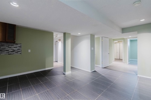 Expansive interior space featuring dark gray tile flooring and recessed lighting - 2439 112 Street Nw, Edmonton, AB - Indoor Photo Showing Other Room