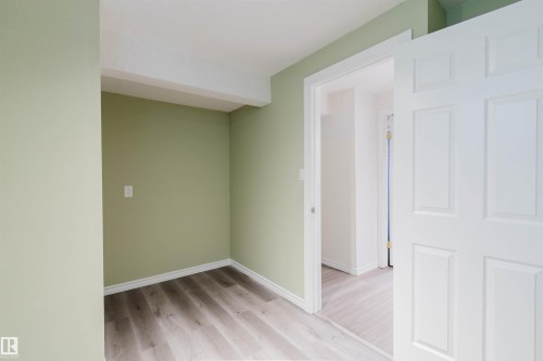Recessed area with wood-finish flooring and light green walls - 2439 112 Street Nw, Edmonton, AB - Indoor Photo Showing Other Room