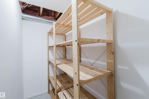 Versatile wood shelving unit within an interior space featuring white walls and a visible duct - 2439 112 Street Nw, Edmonton, AB - Indoor With Storage