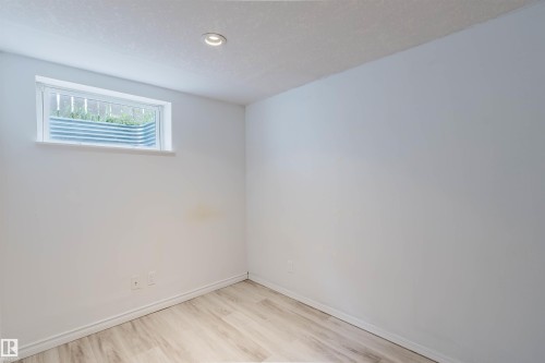 Light-toned wood-finish flooring complements the neutral wall color - 2439 112 Street Nw, Edmonton, AB - Indoor Photo Showing Other Room