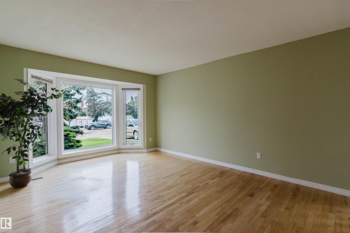 Spacious room with a prominent bay window featuring multiple panes of glass and white trim - 2439 112 Street Nw, Edmonton, AB - Indoor Photo Showing Other Room