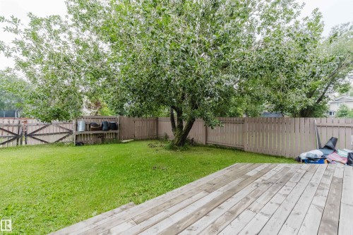 Expansive backyard featuring a wood deck, mature trees, a manicured lawn, and a privacy fence - 2439 112 Street Nw, Edmonton, AB - Outdoor With Backyard