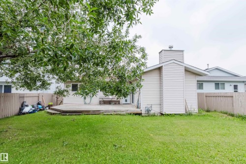 Expansive backyard featuring a manicured lawn, mature trees, and a wooden deck - 2439 112 Street Nw, Edmonton, AB - Outdoor