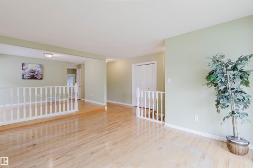 Bright interior with light green walls and wood-finish flooring - 2439 112 Street Nw, Edmonton, AB - Indoor Photo Showing Other Room