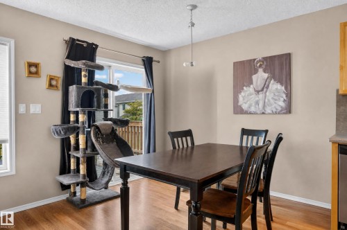 Wood-finish flooring with a neutral wall color, featuring a sliding glass door to an outdoor deck - 21312 48 Avenue Nw, Edmonton, AB 