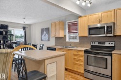 Kitchen featuring wood-finish cabinetry, stainless steel appliances, and a tiled backsplash - 