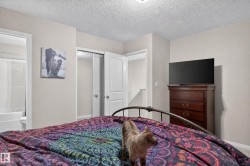 White paneled interior doors, wall-to-wall carpeting, and an adjoining bathroom featuring a white tub - 
