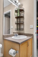 Bathroom vanity with an integrated sink, wood-finish cabinetry, and a neutral countertop - 