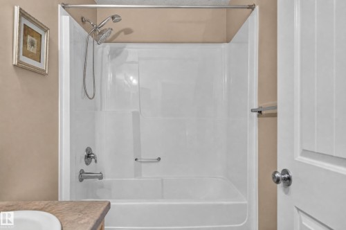 White acrylic tub-shower combination with a chrome dual showerhead and faucet - 21312 48 Avenue Nw, Edmonton, AB 