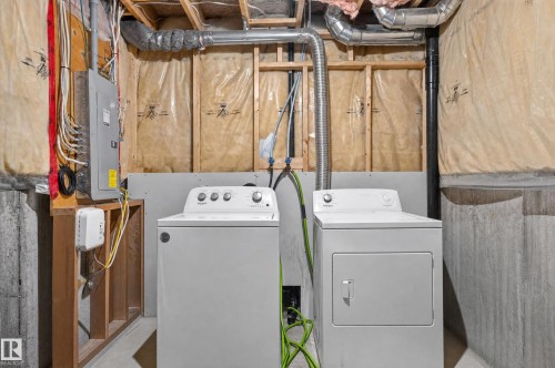 Laundry area featuring a washer and dryer, exposed ductwork, and an electrical panel - 21312 48 Avenue Nw, Edmonton, AB 