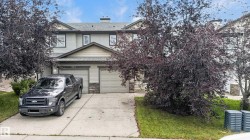 Siding exterior with a pitched roofline, stone accents, and an attached two-car garage - 