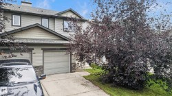 Two-story exterior with horizontal siding and shingle accents, stone veneer detailing, and an attached single-car garage - 