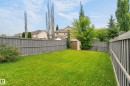 Expansive backyard featuring a manicured lawn, surrounding privacy fence, and a storage shed - 21312 48 Avenue Nw, Edmonton, AB 