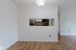 Wood-finish flooring, white walls, and a kitchen pass-through with built-in microwave and range - 