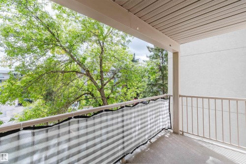Private balcony with a durable concrete surface, painted metal railings, and a soffit ceiling - #316 17109 67 Av Nw, Edmonton, AB 