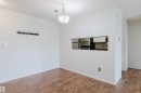 Wood-finish flooring throughout, with a built-in wall cutout to the kitchen - #316 17109 67 Av Nw, Edmonton, AB 