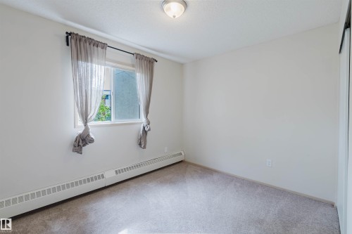 Wall-to-wall carpeting, white painted walls, and a white ceiling with a flush-mount light fixture - #316 17109 67 Av Nw, Edmonton, AB 