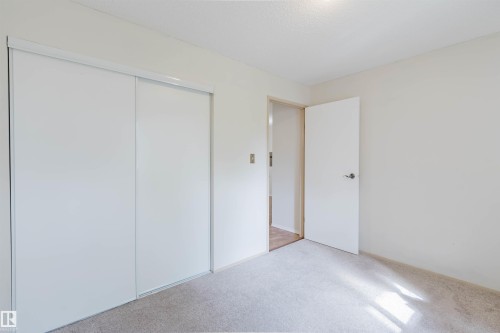 Sliding closet doors, carpeted flooring, white walls, and a ceiling light fixture - #316 17109 67 Av Nw, Edmonton, AB 