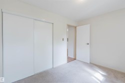 Sliding closet doors, carpeted flooring, white walls, and a ceiling light fixture - 