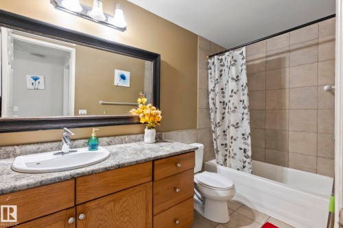Wood-finish vanity with a single basin sink and light-toned countertop - 716 Clareview Rd Nw, Edmonton, AB 