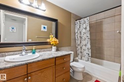 Wood-finish vanity with a single basin sink and light-toned countertop - 