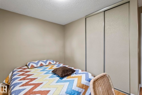 Sliding closet doors with textured panels, neutral wall tones, and wood-finish flooring - 716 Clareview Rd Nw, Edmonton, AB 