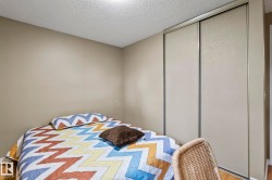 Sliding closet doors with textured panels, neutral wall tones, and wood-finish flooring - 